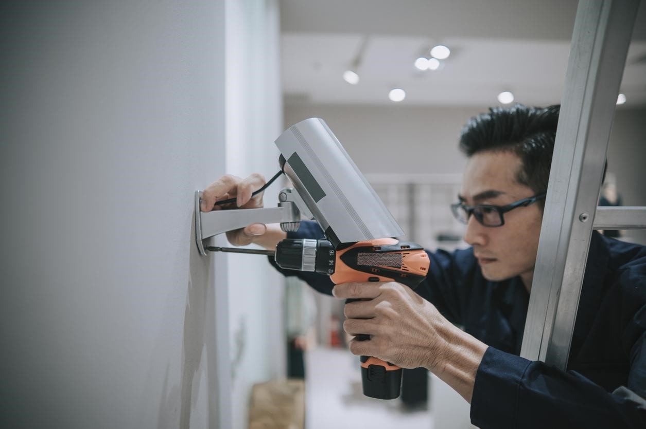 Asian man installing cctv camera